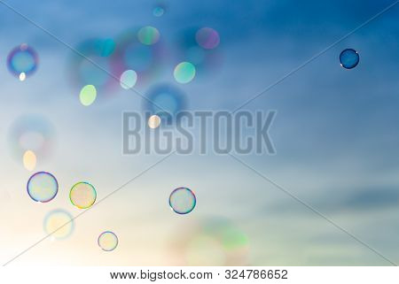 Colorful Soap Bubbles Flying Towards The Sunset Sky.