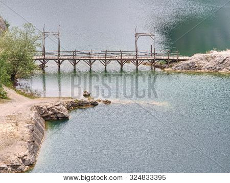 Green Blue Lake With Wooden Tourist Path Bridge Above Cold Water. Hiking In The National Park