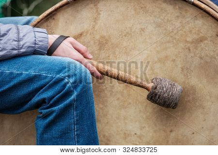 A Street Musician Beating A Big Drum With A Stick. In The Fall In Street Clothes On The Street The D