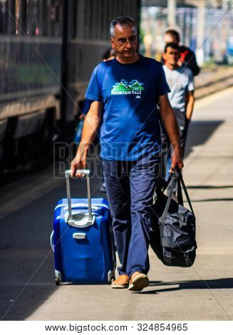 Man Walking Alone Carrying Luggage And Waits Train On The Platform Of Bucharest North Railway Statio