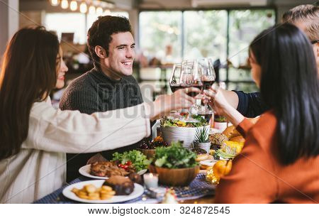 Dinner With Friends. Group Of Young People Enjoying Dinner Together. Dining Wine Cheers Party Thanks
