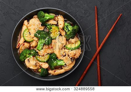 Hunan Chicken In Black Bowl At Dark Slate Background. Hunan Chicken Is Chinese Or Indo-chinese Cuisi