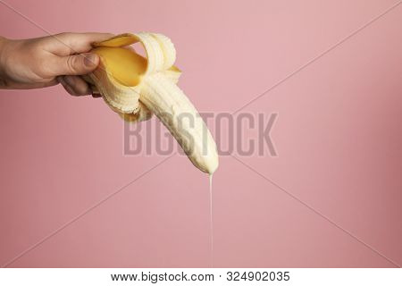 Big Banana And Drops Of Condensed Milk. Concept Of Sex, Man Ejaculation. Sperm And Orgasm.