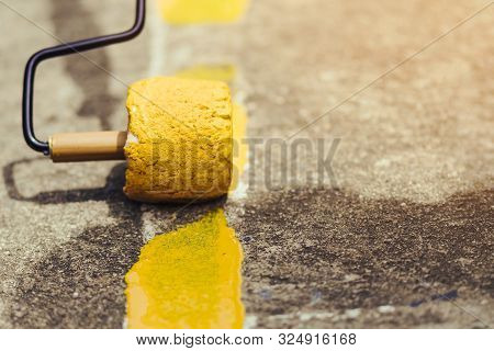 Male Students Use Small Paint Rollers To Paint Yellow Lines On The Cement Floor For Sepak Takraw Tra