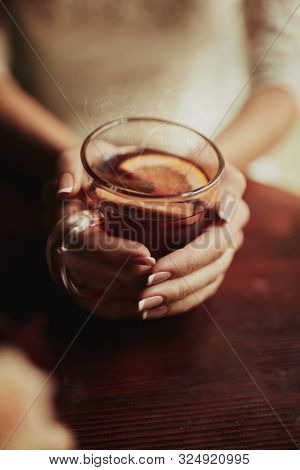 Young Bride Drinking Tea. Wedding Bouquet On A Wooden Table In A Restaurant. Cropped Image Of Bride 