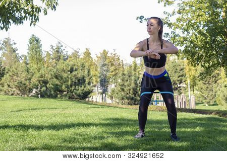 Rubber Squat. Fitness. Athlete Girl, Thlete Exercise At Outside, Woman Fitness. Young Beautiful Woma