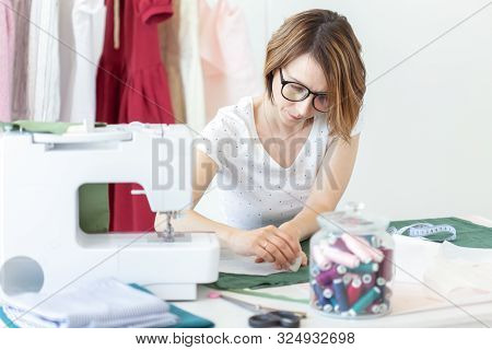 Young Pretty Girl Student Study At A Clothes Designer In College And Does Her First Thesis Sitting A