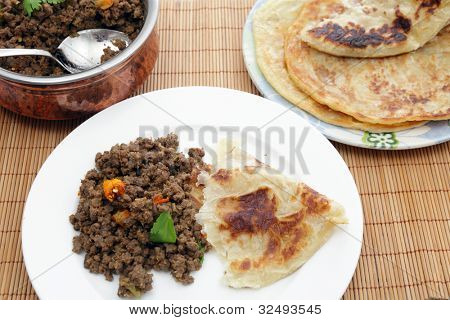 Et hakket oksekød nord indisk eller pakistansk keema karry serveret med paratha flade brød, en traditionel ac