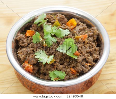 Et hakket oksekød eller keema karry i en serveringsskål, garneret med korianderblade