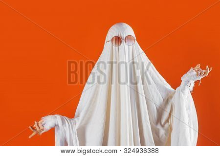 Happy Halloween. Cute Funny Ghost On A Bright Orange Background. Sheet Ghost Costume, Halloween Part