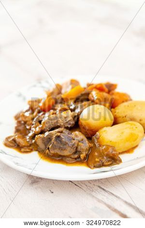 Beef meat stewed with potatoes-Traditional French cuisine Beef Bourguignon potatoes carrots in persillade