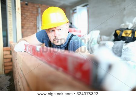 Portrait Of Bearded Builder Wearing Hard Gloves To Keep Hands Unharmed. Professional Man Using Speci