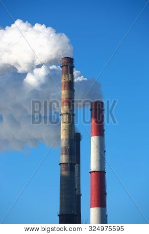 White Smoke Comes From Pipes Against Blue Sky. Problem Harmful Emissions And Air Pollution Of Centra
