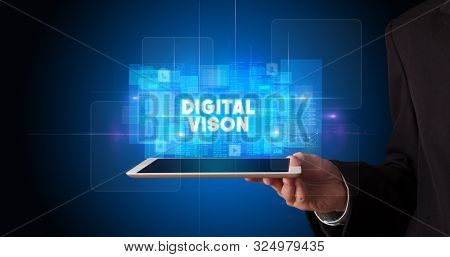 Young business person working on tablet and shows the inscription: DIGITAL VISON