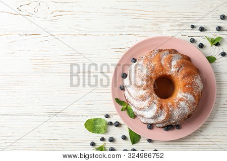 Cake With Powder Sugar And Blueberry On Wooden Background, Top View