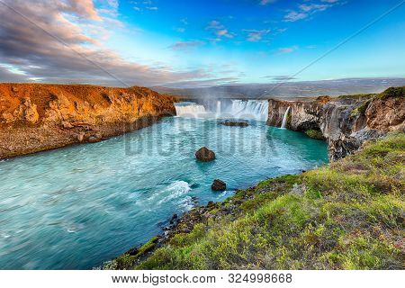 Breathtaking Sunset Landscape Scene Of Powerful Godafoss Waterfall. Dramatic Sky Over Godafoss. Loca