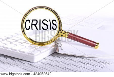 Crisis Word Through Magnifying Glass On The Keyboard On The Chart