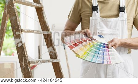 Hands Of House Painter Man Decorator Choose The Color Using The Sample Swatch, Work Of The House To 