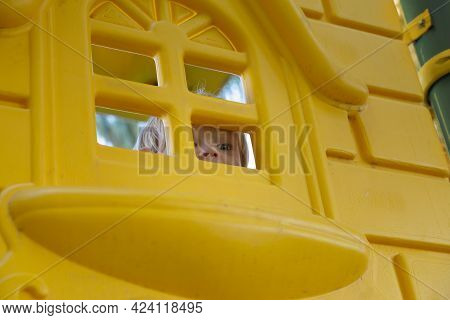 Child Plays In The Playground, Looks Out Of The Window.
