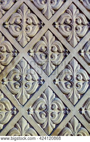 Ornate Repetitive Floral Themed Patterns Sculptured On A Stone Wall.