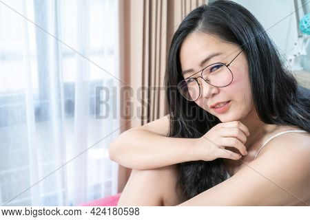Asian Glasses Woman Relax On Her Bed In The Morning At Her Bedroom.