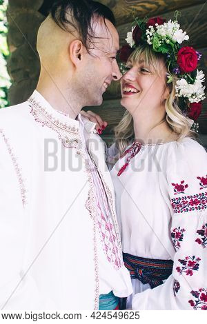 Young People Are Posing In Traditional Folk Costumes. Cossacks Man And Woman In Wreaths And Embroide