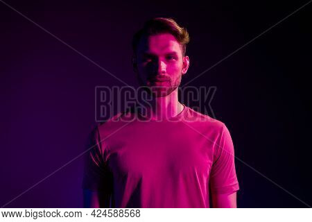 Portrait Of Attractive Serious Content Guy Wearing T-shirt Isolated Over Dark Neon Light Violet Colo