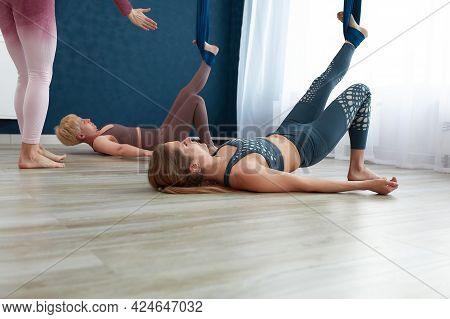 A Couple Of Beautiful Girls Practice Aerial Yoga Of A Woman, Under The Guidance Of An Anti-gravity Y