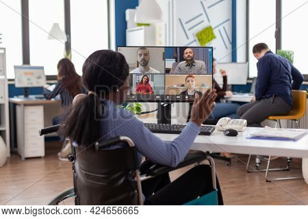 Paralysed Handicapped Black Worker Sitting Immobilized In Wheelchair Having Videomeeting Discussing 