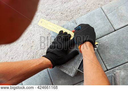 Worker lining paving slabs path