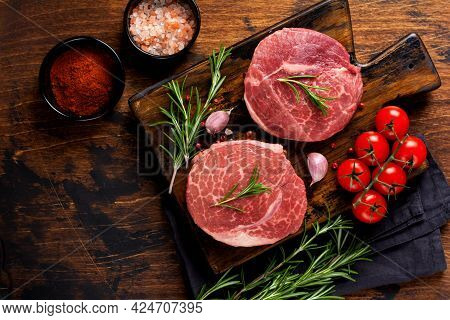 Two Fresh Parisienne Raw Steak On Wooden Board With Salt, Pepper And Rosmary In A Rustic Style On Ol