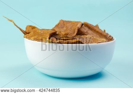 Fragrant Training Treats For Pets On Blue Background. Natural Air Dried Dog Treats In A White Cerami