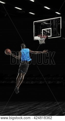 One Young Sportsman Basketball Player Training In Gym, Idoors Isolated On Dark Background. Concept O