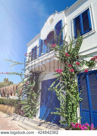 Bodrum, Turkey. Pink Bougainvillea Flowers And Old Blue Door On White House In Bodrum.