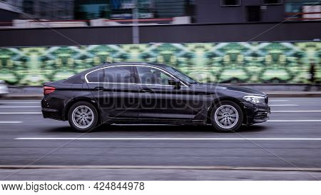Moscow, Russia - April 2021: Side View Of Bmw 5 Series In Motion. Black Sedan Car Moving On The Stre