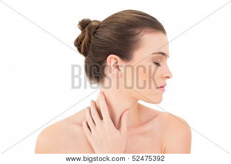 Serious woman closing her eyes and touching her neck against white background