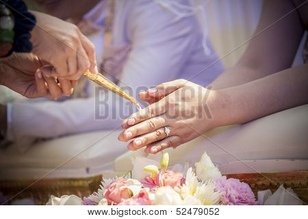 Hands Pouring Blessing Water Into Bride's Bands, Thai Wedding Ceremony