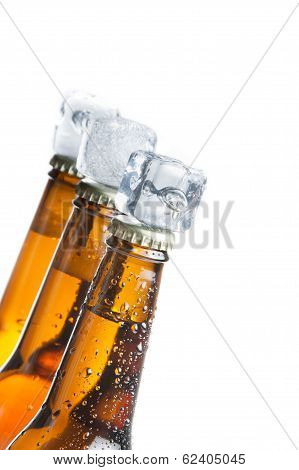 Three Tilted Bottle Of Fresh Beer With Ice On Top And Drops,concept Of Fresh Beer On Summer