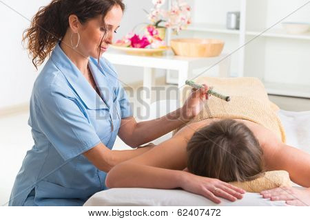 Alternative medicine therapist doing moxa treatment on her client