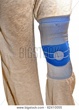 Sports Knee Brace - A Stabilizing Silicone Blue And Gray Medical Sports Knee Brace Worn Over Sweatpa