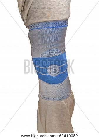 Sports Knee Brace - A Stabilizing Silicone Blue And Gray Medical Sports Knee Brace Worn Over Sweatpa