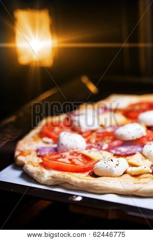 Raw pizza dough with mozzarella and proscuitto on top