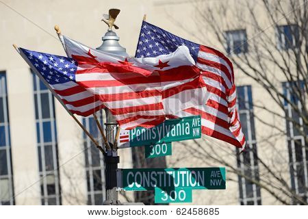 Washington DC, Pennsylvania Avenue and Constitution Avenue junction street signs with DC and United States of America flags on the same post 