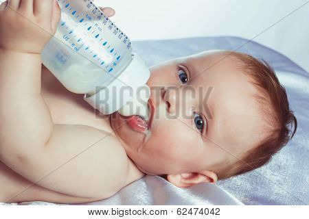 Babe with blue eyes is holding a bottle