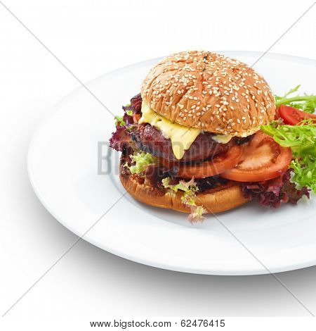 Fresh tasty hamburger with geilled patty and cheese served with vegetables. Isoltaed on white.