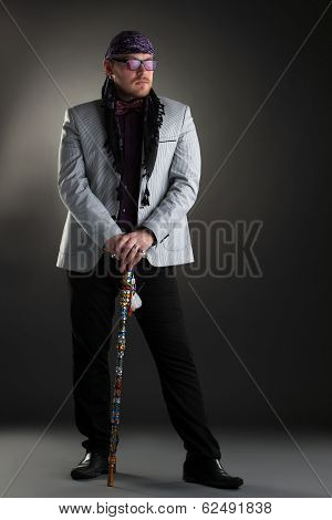 Image of racy man posing with cane in studio