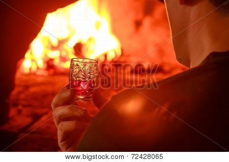 Crystal glass and burning wood in hearth furnace