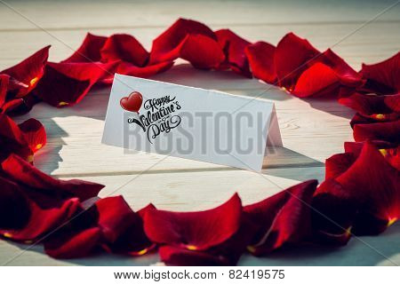 Cute valentines message against card surrounded by petals