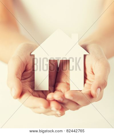 closeup pisture of woman hands holding paper house