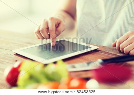 cooking, technology and home concept - closeup of man pointing finger to tablet pc computer
